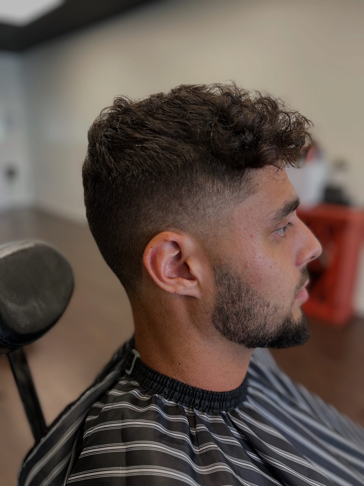 Curly fringe with a low fade and clean neckline, barbered in downtown Missoula