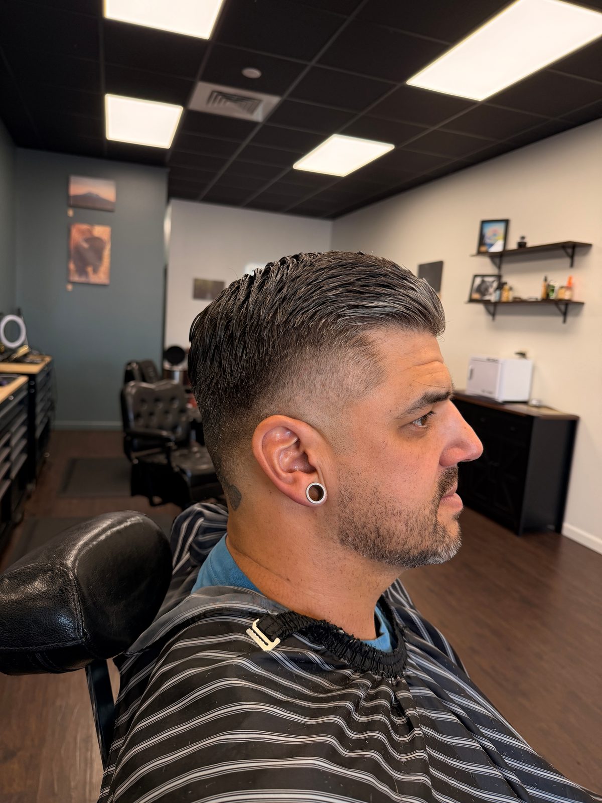Slicked side part with a razor line and mid fade, cut at The Barber Studio Missoula
